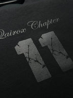 QAIROX Chapter Tee close-up — Qairox Chapter script with cracked texture 11 graphic, premium screen print detail on black cotton