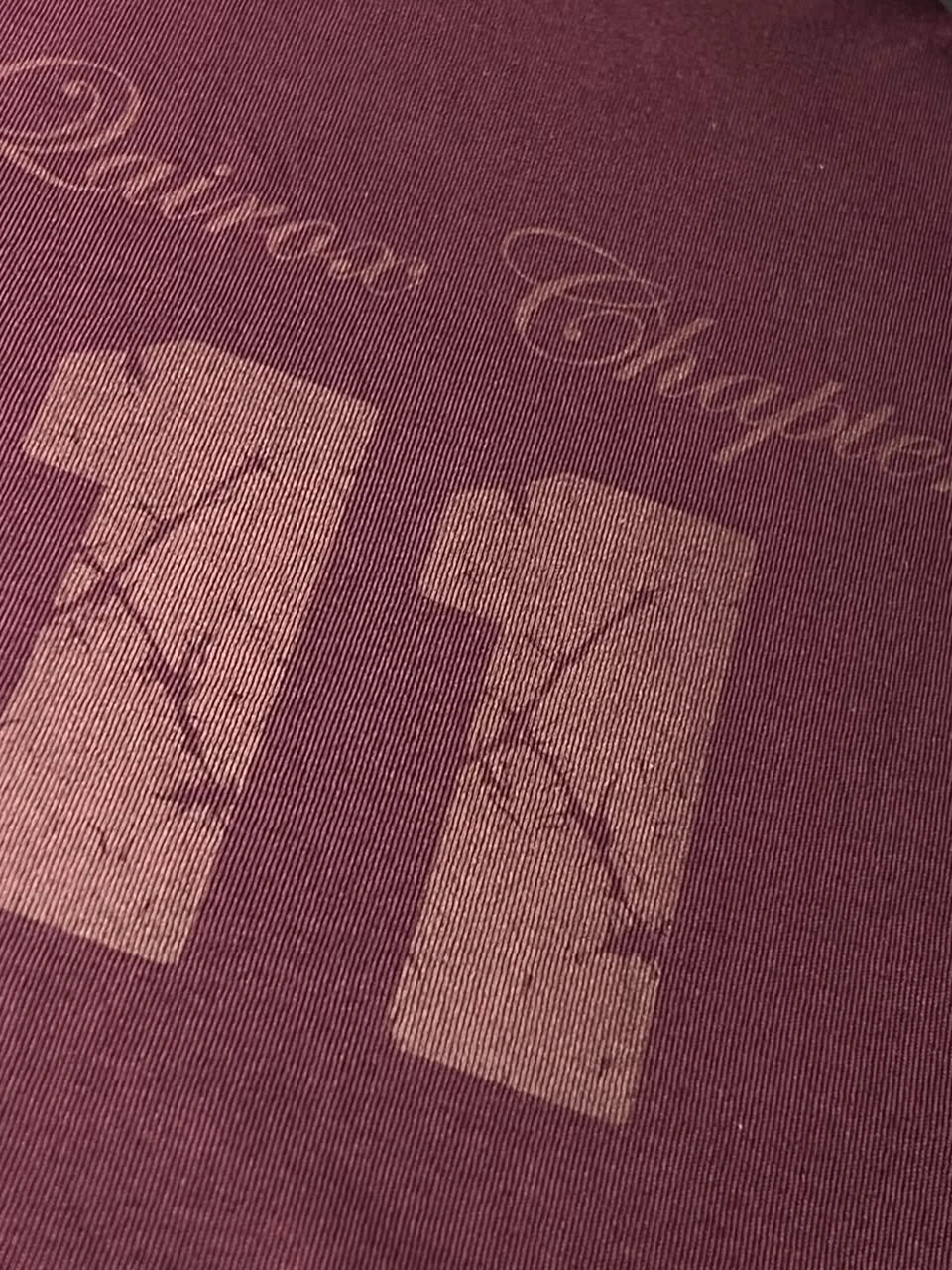 QAIROX Chapter Tee burgundy close-up — tone-on-tone Qairox Chapter 11 print detail, refined cracked texture on 285 GSM interlock