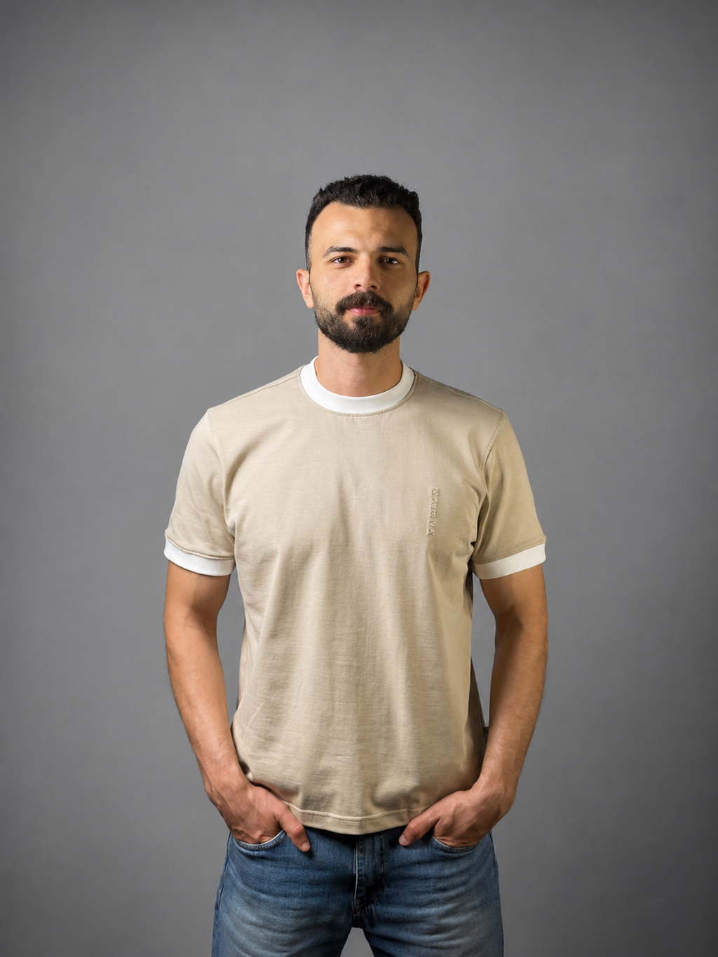 Man wearing QAIROX beige ringer tee with white contrast collar and cuffs